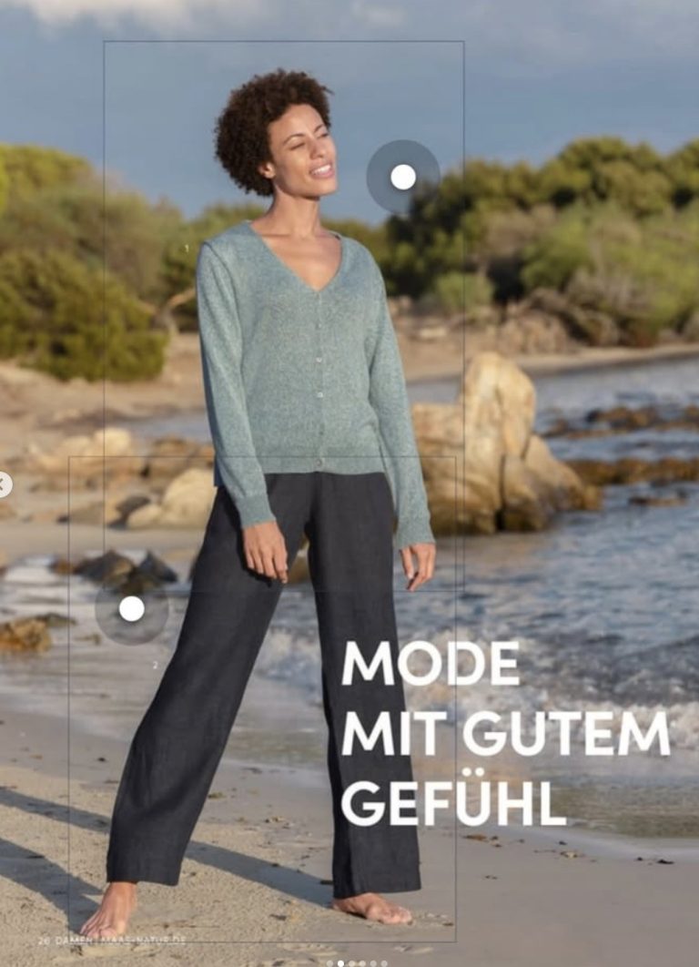 Katalogseite „Mode mit gutem Gefühl“: Frau in grünem Strickpullover und dunkler Hose am Strand