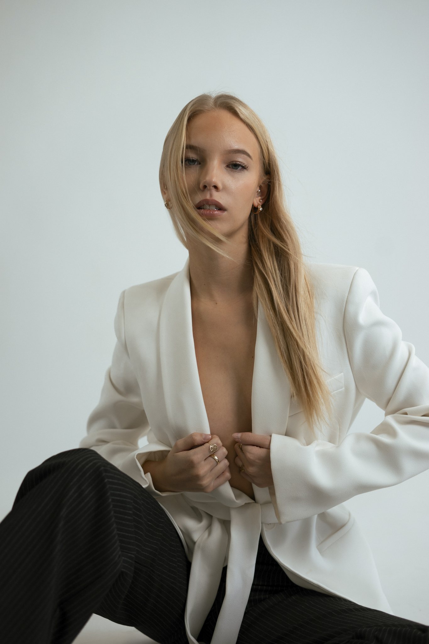 Blonde Frau im weißen Blazer, sitzend